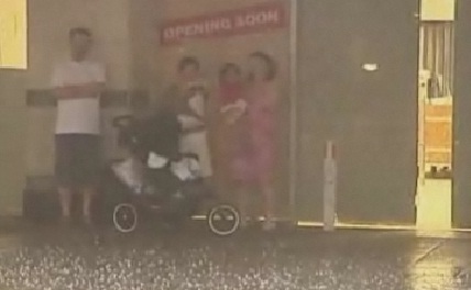 Family seen taking shelter by an amateur camera man from the storm in Perth as hail stones the size of golf balls battered the city