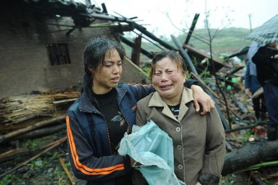 Two women support each other after both loose relatives to the devastating storms which hit Southeast China Wednesday and Thursday - Photo by : Xinhua/Zhou Hengyi