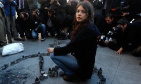 Chilean student leader Camila Vallejo sits among a peace sign created from empty teargas canisters used by police against protesters. 