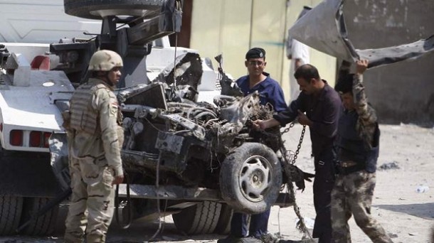 Iraqi security personnel inspect the site of a car bomb attack in Basra, 420 km (261 miles) southeast of Baghdad