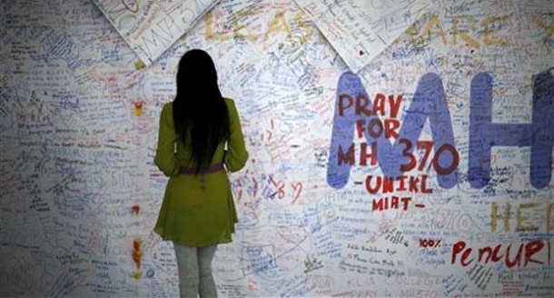 A woman reads messages and extends well wishes to passengers onboard Malaysia Airlines MH370 missing.  File pic